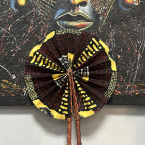 Abanico negro con diseño en amarillo, blanco y rojo